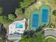 Overhead shot of community amenities including a pool, tennis courts, and pond surrounded by trees at 8720 Larwin Ln, Orlando, FL 32817