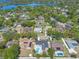 Aerial view of a residential neighborhood with mature trees and a lake in the distance at 8720 Larwin Ln, Orlando, FL 32817