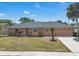 Charming single-story home featuring a tidy lawn and a two-car garage, all under a sunny blue sky at 8720 Larwin Ln, Orlando, FL 32817