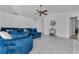 Spacious living area with fan, tile floors, and comfortable blue seating at 8720 Larwin Ln, Orlando, FL 32817