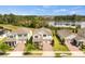 Aerial view showcasing three well-manicured homes near a tranquil lake, highlighting curb appeal and community setting at 9687 Lost Creek Dr, Winter Garden, FL 34787