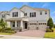 Charming two-story home with a brick driveway and a two-car garage, offering a blend of style and functionality at 9687 Lost Creek Dr, Winter Garden, FL 34787