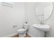 Clean half bathroom featuring a pedestal sink, toilet, and minimalist decor, perfect for guests at 9687 Lost Creek Dr, Winter Garden, FL 34787