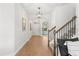 Bright hallway with tiled floors, a staircase with iron railings, and views into the home's living spaces at 9687 Lost Creek Dr, Winter Garden, FL 34787