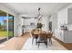 Bright kitchen and dining area with white cabinets, stainless steel appliances, and a view of the backyard at 9687 Lost Creek Dr, Winter Garden, FL 34787