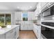 Bright kitchen with white cabinets, modern appliances, and a view of the backyard through a sliding door at 9687 Lost Creek Dr, Winter Garden, FL 34787