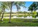 Enjoy the serene view of the pond from your backyard featuring lush green grass and trees at 150 Golfside Cir, Sanford, FL 32773