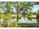 Scenic golf course view featuring a serene pond and lush green fairways, under a bright, sunny sky at 150 Golfside Cir, Sanford, FL 32773