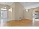 Open living space featuring hardwood floors, arched entryways, and a modern chandelier, adjacent to tiled foyer at 150 Golfside Cir, Sanford, FL 32773