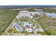 Stunning aerial view of the resort's pools, water slides, and upscale condo buildings by the lake at 14501 Grove Resort Ave # 3222, Winter Garden, FL 34787