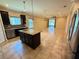 Granite island is the focal point of this well-lit kitchen, open to the living area at 2815 Moonstone Bnd, Kissimmee, FL 34758