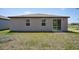 This exterior shot shows the home's backyard, featuring a sliding door, windows and grassy area at 3218 Viceroy Ct, Poinciana, FL 34759