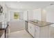 Kitchen with stainless steel dishwasher, island with sink, and sliding glass doors leading to the backyard at 3218 Viceroy Ct, Poinciana, FL 34759