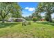 Sprawling backyard with lush green lawn, mature trees, and a detached garage or shed at 4570 Chambliss Rd, Winter Haven, FL 33884