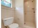 Bathroom featuring tile flooring and walls, a toilet, and a walk-in shower with a built-in soap holder at 4570 Chambliss Rd, Winter Haven, FL 33884