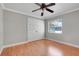 Neutral bedroom features a ceiling fan, light wood floor, large closet, and a window at 4570 Chambliss Rd, Winter Haven, FL 33884