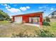 Red garage with a covered patio, ceiling fan, and additional covered parking at 4570 Chambliss Rd, Winter Haven, FL 33884