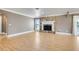 Open living room with light hardwood floors, a stone fireplace, and natural light at 4570 Chambliss Rd, Winter Haven, FL 33884