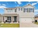 Two-story home with stone-accented columns, covered porch, two-car garage, and manicured lawn at 828 Sheen Cir, Haines City, FL 33844