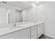 Modern bathroom with double sinks, white cabinets, and a glass-enclosed shower at 836 Poppy Ln, Dundee, FL 33838