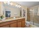 Bathroom featuring double sinks, a large mirror and a glass enclosed shower at 8944 Sugar Palm Rd, Kissimmee, FL 34747