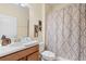 Standard bathroom with vanity, white sink, toilet, and patterned shower curtain and wall art at 8944 Sugar Palm Rd, Kissimmee, FL 34747