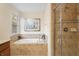 Bathroom featuring a glass enclosed shower, a garden tub and a window at 8944 Sugar Palm Rd, Kissimmee, FL 34747