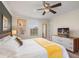This bedroom has ample natural light, a ceiling fan, and decorative artwork for a serene retreat at 8944 Sugar Palm Rd, Kissimmee, FL 34747