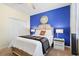 Cozy bedroom with blue accent wall, comfortable queen bed, and bedside tables with lamps at 8944 Sugar Palm Rd, Kissimmee, FL 34747