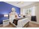 Cozy bedroom with a large window, ceiling fan, and a calming blue accent wall at 8944 Sugar Palm Rd, Kissimmee, FL 34747