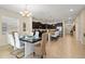 Dining room featuring a dining table with seating for six, an open kitchen, and tile flooring at 8944 Sugar Palm Rd, Kissimmee, FL 34747