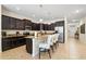 Open-concept kitchen featuring dark cabinetry, granite countertops, a kitchen island, and stainless steel appliances at 8944 Sugar Palm Rd, Kissimmee, FL 34747