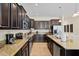 This kitchen features stainless steel appliances, granite countertops, and dark wood cabinets at 8944 Sugar Palm Rd, Kissimmee, FL 34747