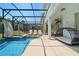 Resort-style screened-in pool with a spa, lounge chairs, and a covered patio at 8944 Sugar Palm Rd, Kissimmee, FL 34747