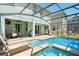Backyard oasis with a sparkling pool, jacuzzi, screened enclosure, and lounge seating at 8944 Sugar Palm Rd, Kissimmee, FL 34747