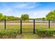 Gated backyard with serene lake views, green lawn and shrubbery at 9254 Reymont St, Orlando, FL 32827