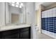 Well-lit bathroom featuring a vanity with a dark cabinet and a shower with a striped curtain at 9254 Reymont St, Orlando, FL 32827