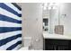 Clean bathroom featuring a modern vanity and a shower with a blue and white striped curtain at 9254 Reymont St, Orlando, FL 32827