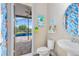 Bright bathroom featuring colorful tropical decor, toilet, and view of the pool at 9254 Reymont St, Orlando, FL 32827