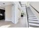 Elegant home foyer with staircase, iron railing, high ceilings, and light wood-look floors at 9254 Reymont St, Orlando, FL 32827