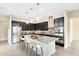 Modern kitchen featuring dark cabinetry, stainless steel appliances, and a center island with barstool seating at 9254 Reymont St, Orlando, FL 32827