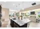 Open kitchen featuring granite counters, large island, pendant lighting, and stainless steel appliances, flowing into the living room at 9254 Reymont St, Orlando, FL 32827
