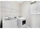 Clean and functional laundry room with modern washer and dryer, and wire shelving for storage at 9254 Reymont St, Orlando, FL 32827
