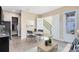 Cozy living room showcasing a staircase view, complemented by a dining table and wood-look flooring at 9254 Reymont St, Orlando, FL 32827