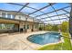 A luxurious backyard screened-in pool features a tranquil waterfall and steps for easy access at 9254 Reymont St, Orlando, FL 32827