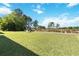 Expansive backyard with well-maintained lawn, mature trees, and view of a community green space at 9826 Heron Pointe Dr, Orlando, FL 32832