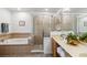 Bathroom featuring tile surround tub, glass enclosed shower, and double sinks at 9826 Heron Pointe Dr, Orlando, FL 32832