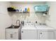Functional laundry room with a utility sink, storage cabinets, washer, and dryer at 9826 Heron Pointe Dr, Orlando, FL 32832