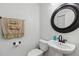 Powder room featuring a pedestal sink, toilet, and decorative mirror at 9826 Heron Pointe Dr, Orlando, FL 32832