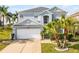 Charming two-story home with a two-car garage, landscaped yard, and tropical palm trees at 119 Horton Park Dr, Davenport, FL 33897